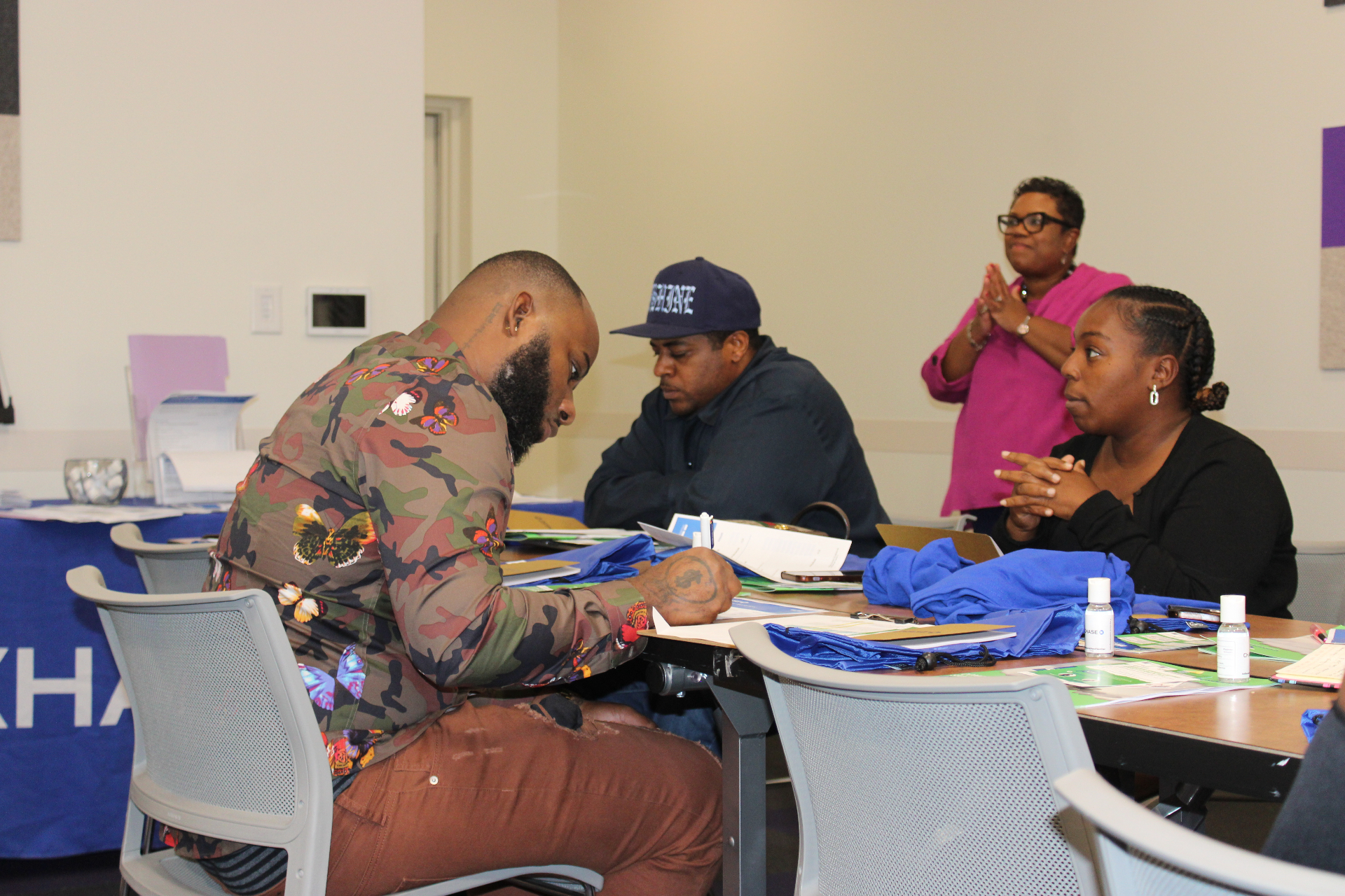Participants completing savings paperwork together at a cohort session