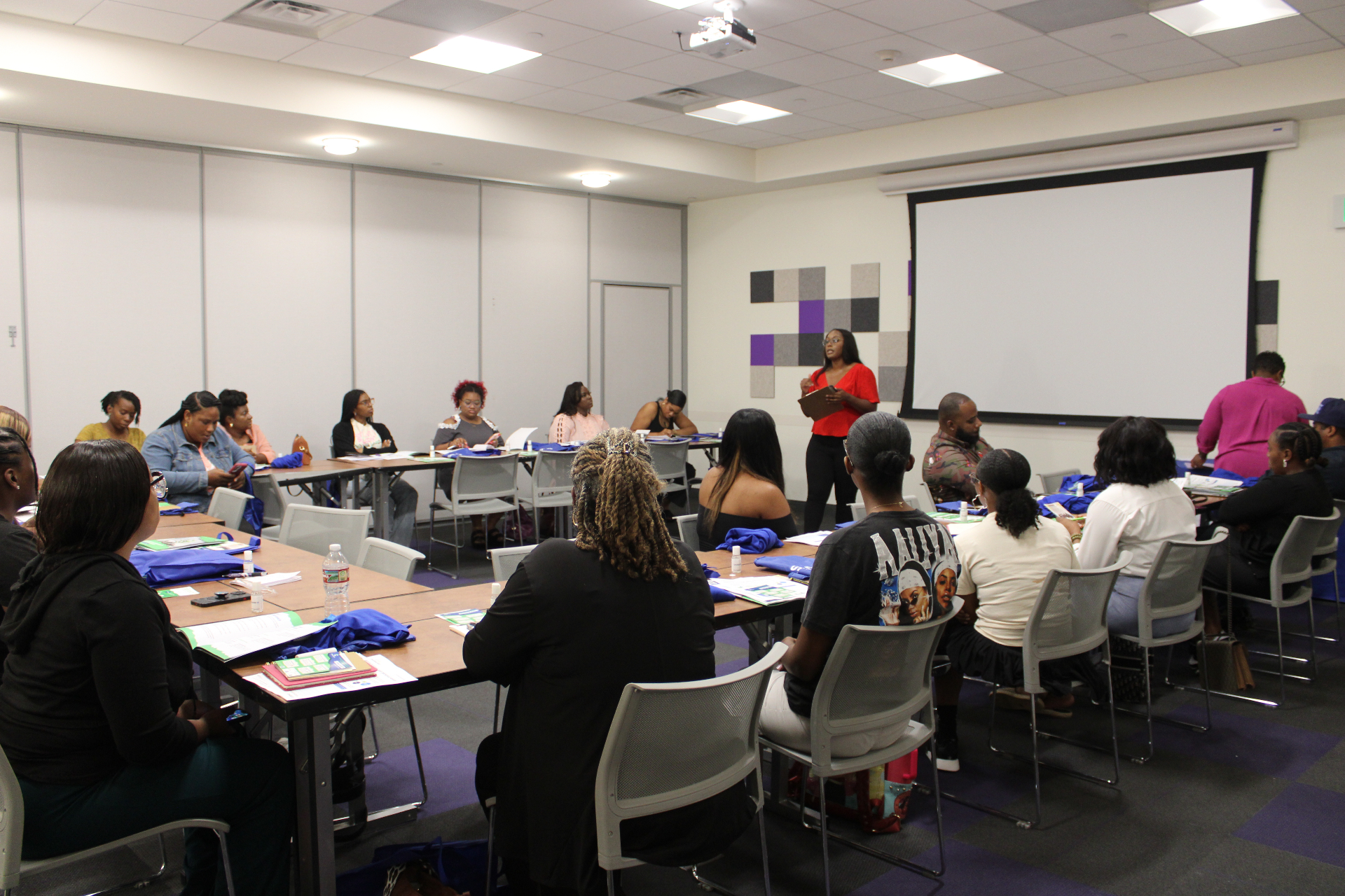 A full room of savings program participants during a cohort workshop