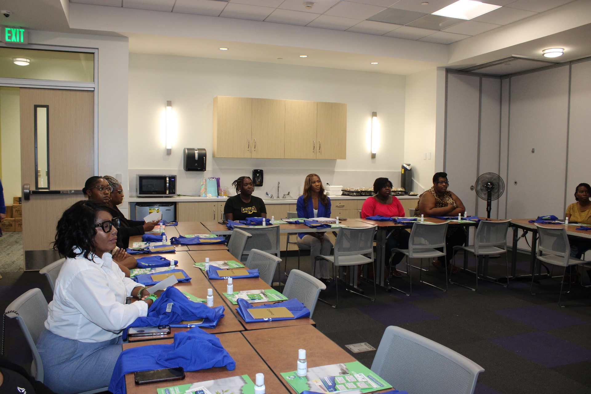 Savings program participants seated around tables during an orientation session